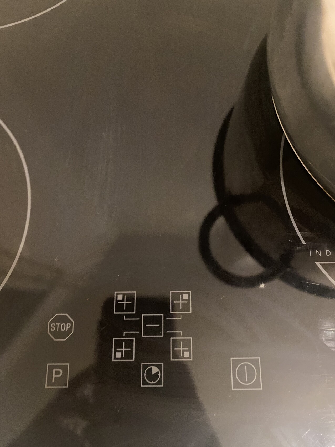 Induction cooktop with touch control panel: central plus/minus buttons, stop and P button.