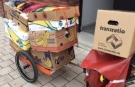 Colorful fruit cart with fruit crates on a paved path.