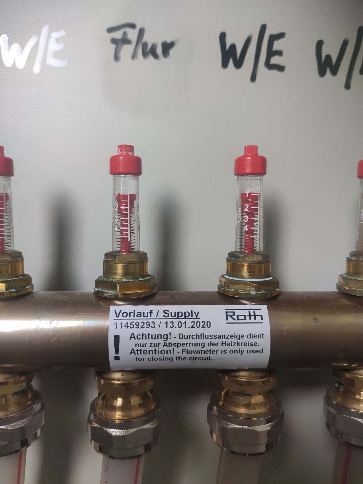 Several flow indicators with red liquid on copper pipe, supply line marked.