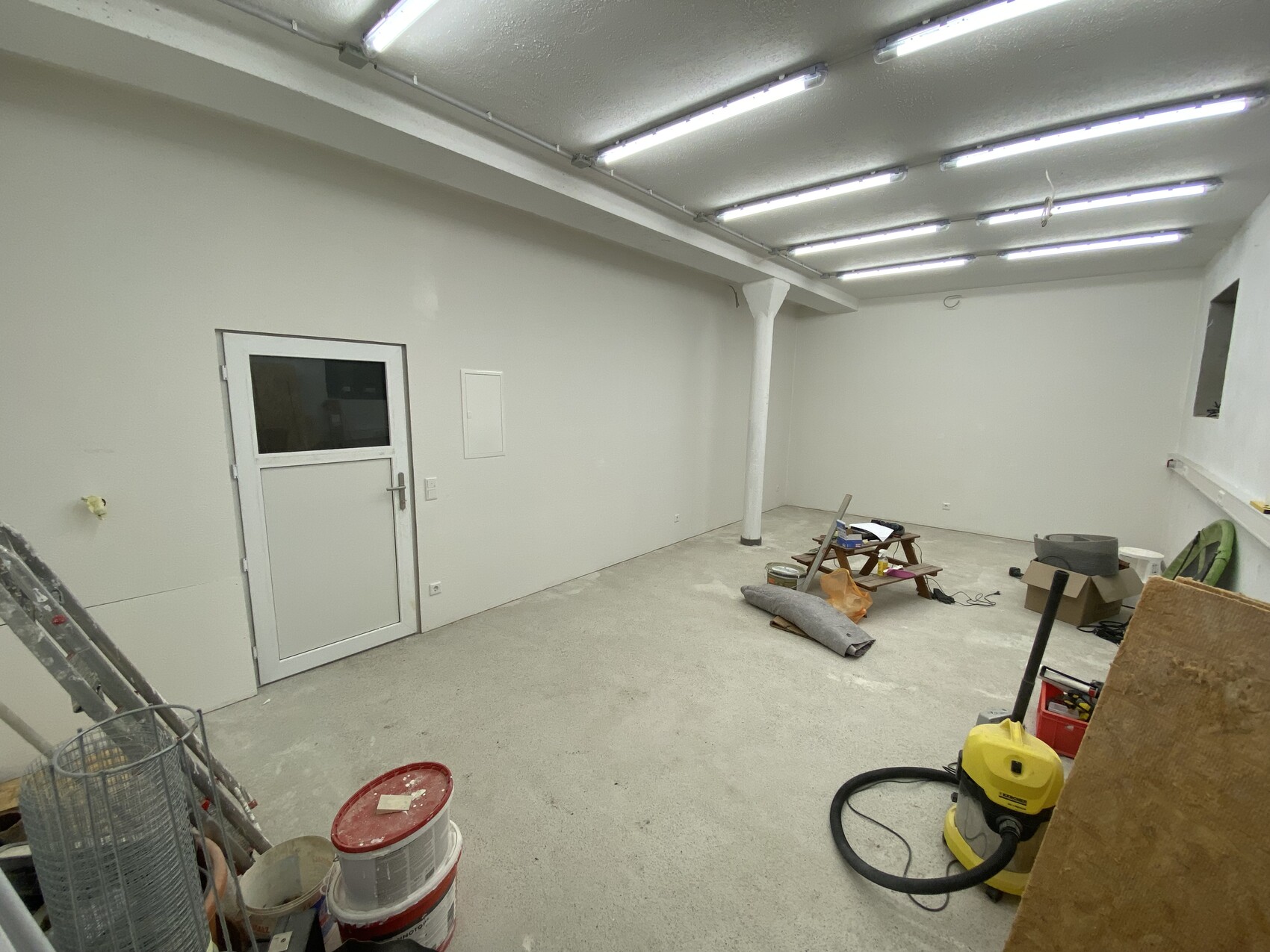 Bright interior under renovation with door, tools, and building materials.