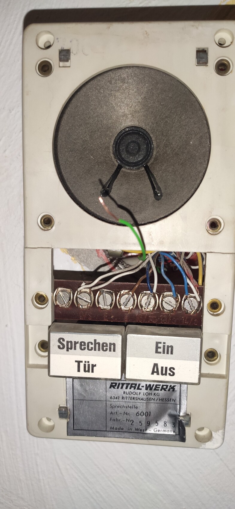 Old door intercom system with wired connections and labeling Talk Door On Off on the wall