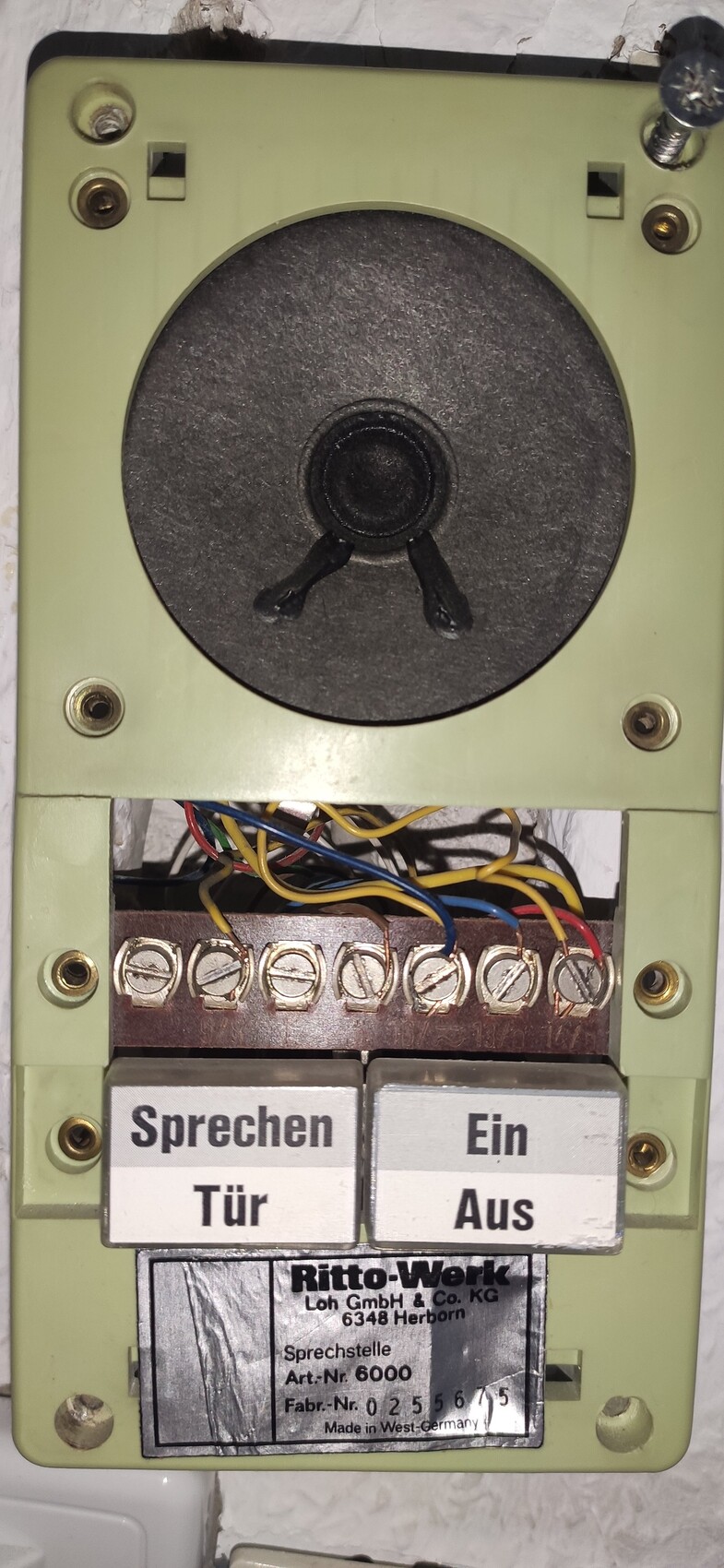 Old door intercom system with screw terminals, wires, and two buttons Talk/Door and On/Off.