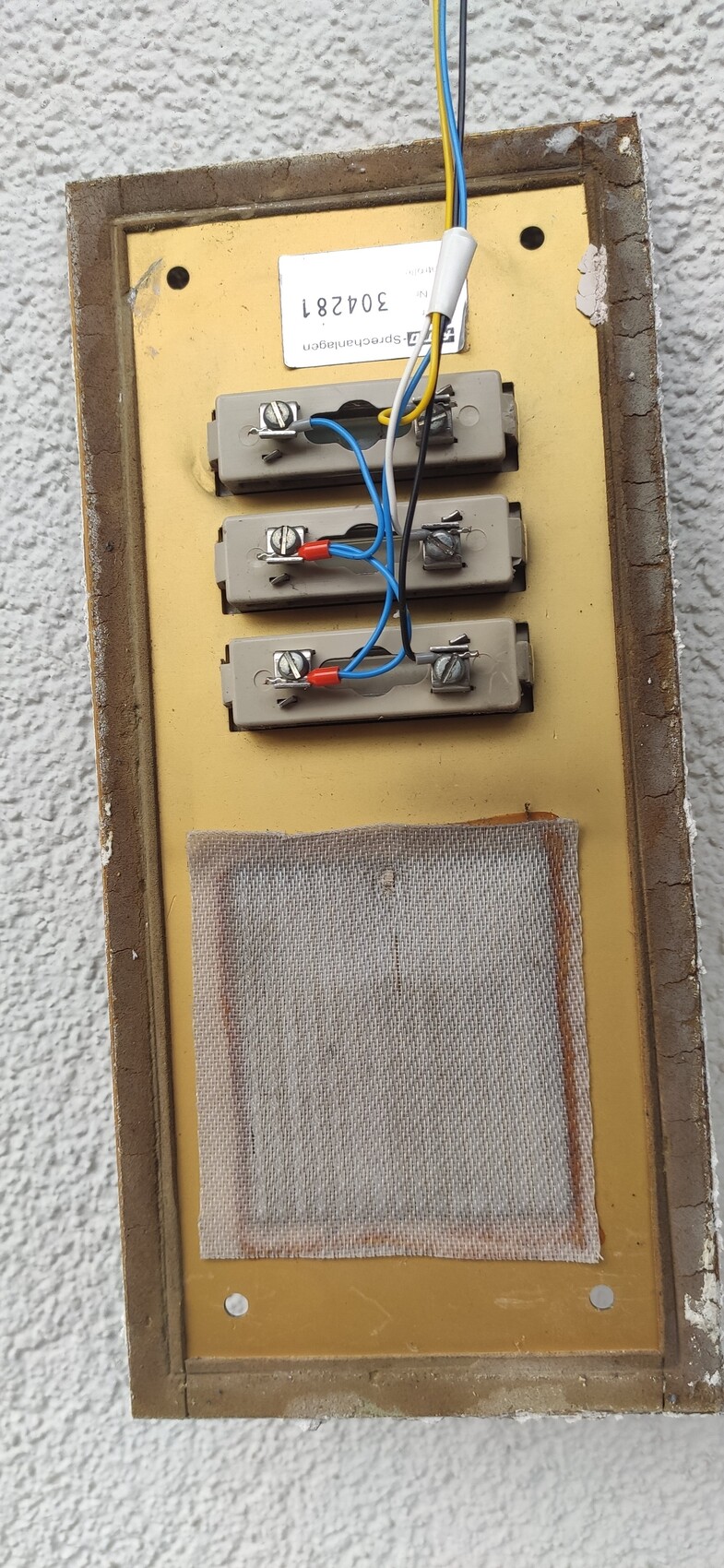 Wall-mounted electrical panel with four terminal blocks, blue and red wire connections.