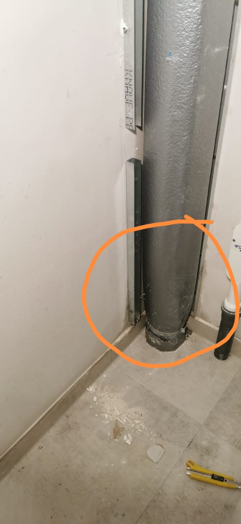 Black pipe in floor corner, orange circle marks floor connection; cutter on floor.
