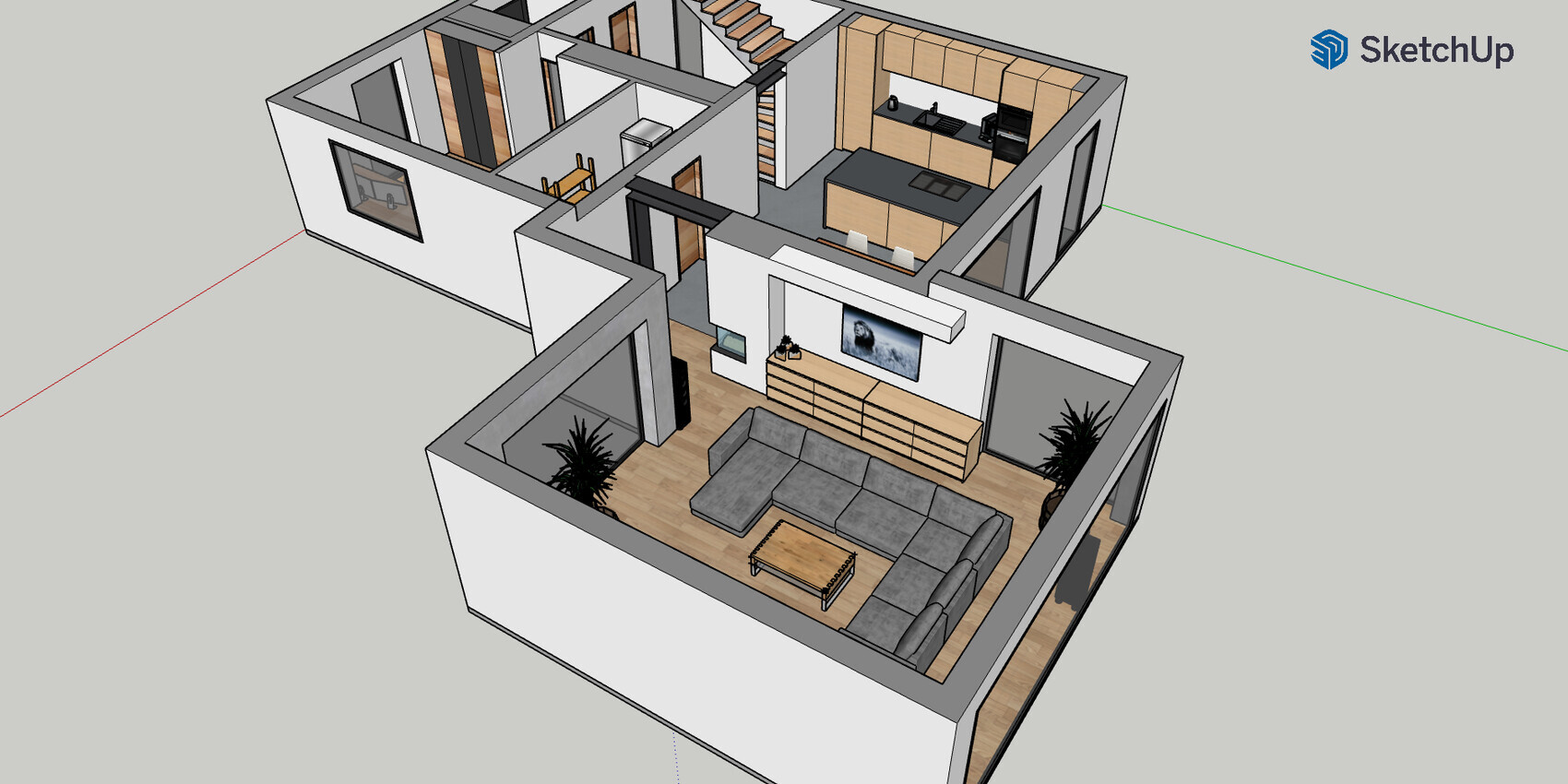 3D view of an open living and kitchen area with gray corner sofa, TV, and stairs