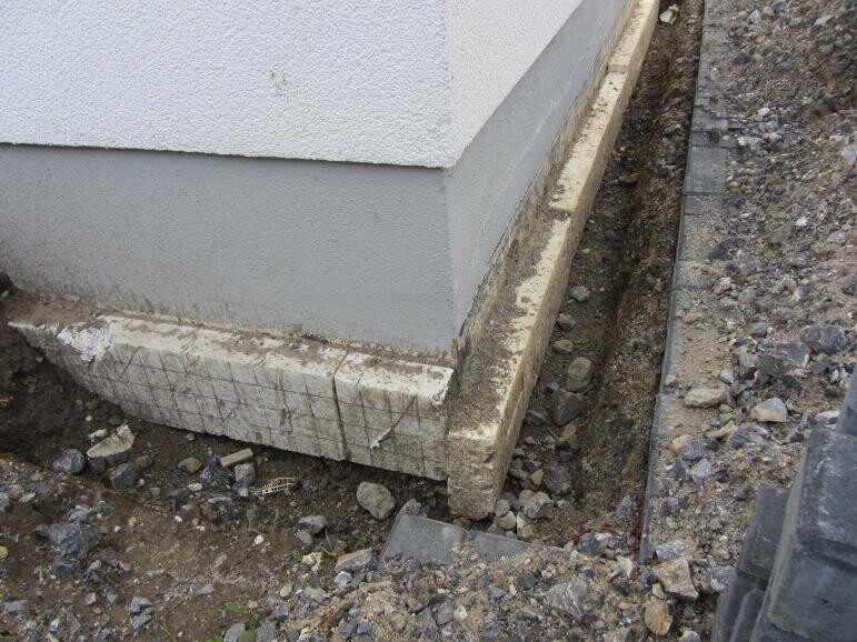 Exterior foundation of house under construction with concrete blocks and earthworks