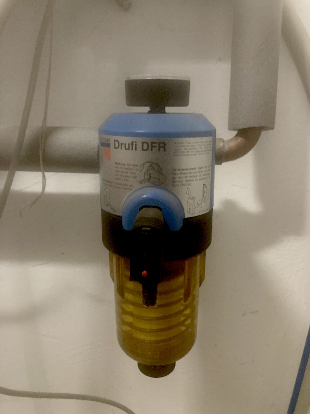 Small water filter pressure regulator on pipe connection under sink