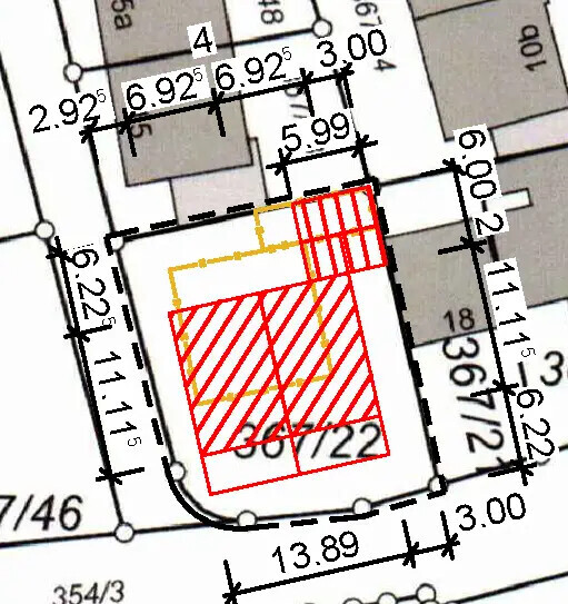 Roter, schraffierter Gebäudebereich auf einem Lageplan, umgeben von Grenzlinien; Maße sichtbar.