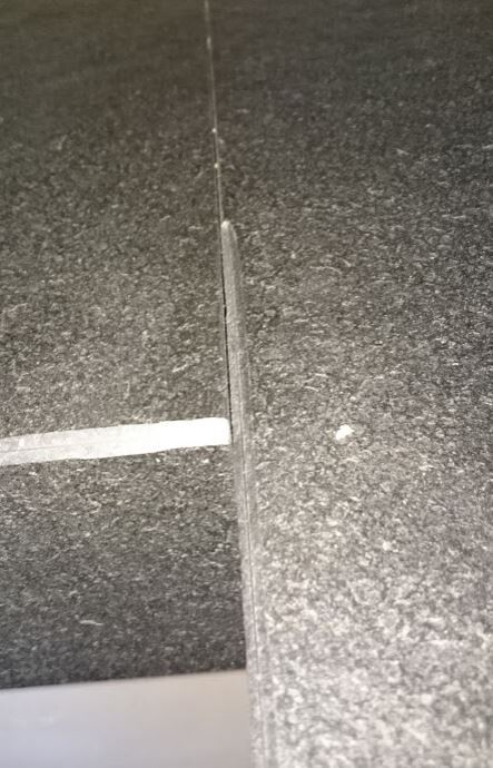 Close-up of a dark tiled floor covering with visible grout line
