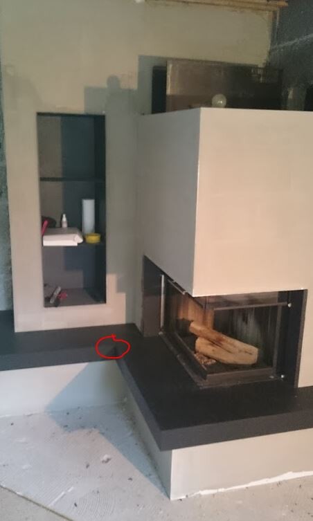 Modern fireplace with black base and white surround in a living room.