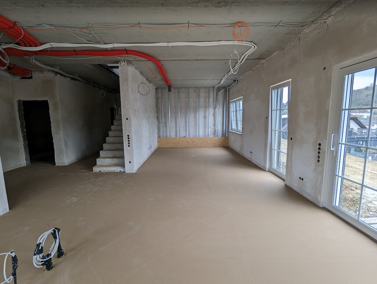 Shell interior with staircase, exposed cables, and unfinished walls in progress