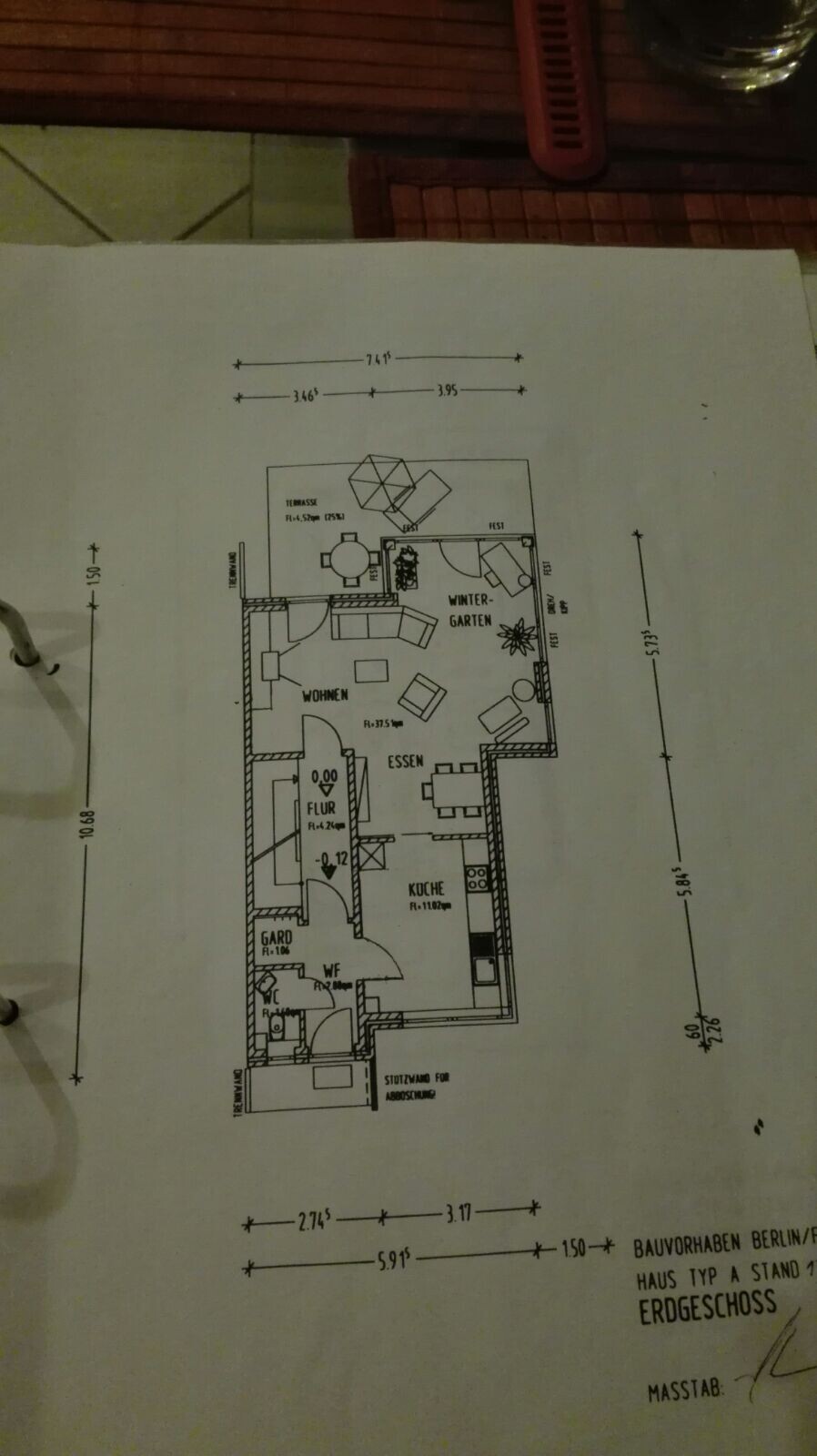 Grundrissplan eines Erdgeschosses mit Küche, Essbereich, Wohnzimmer und Wintergarten.