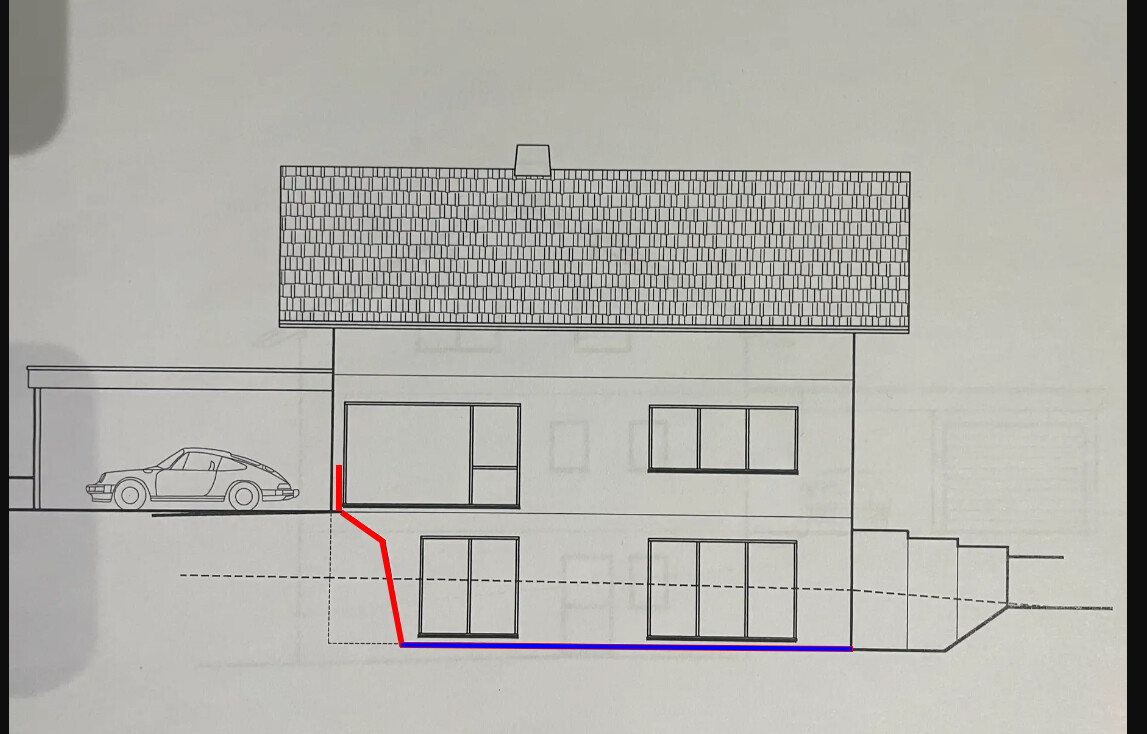 Two-story house with garage on the left, car in carport; red and blue lines mark foundation cut.