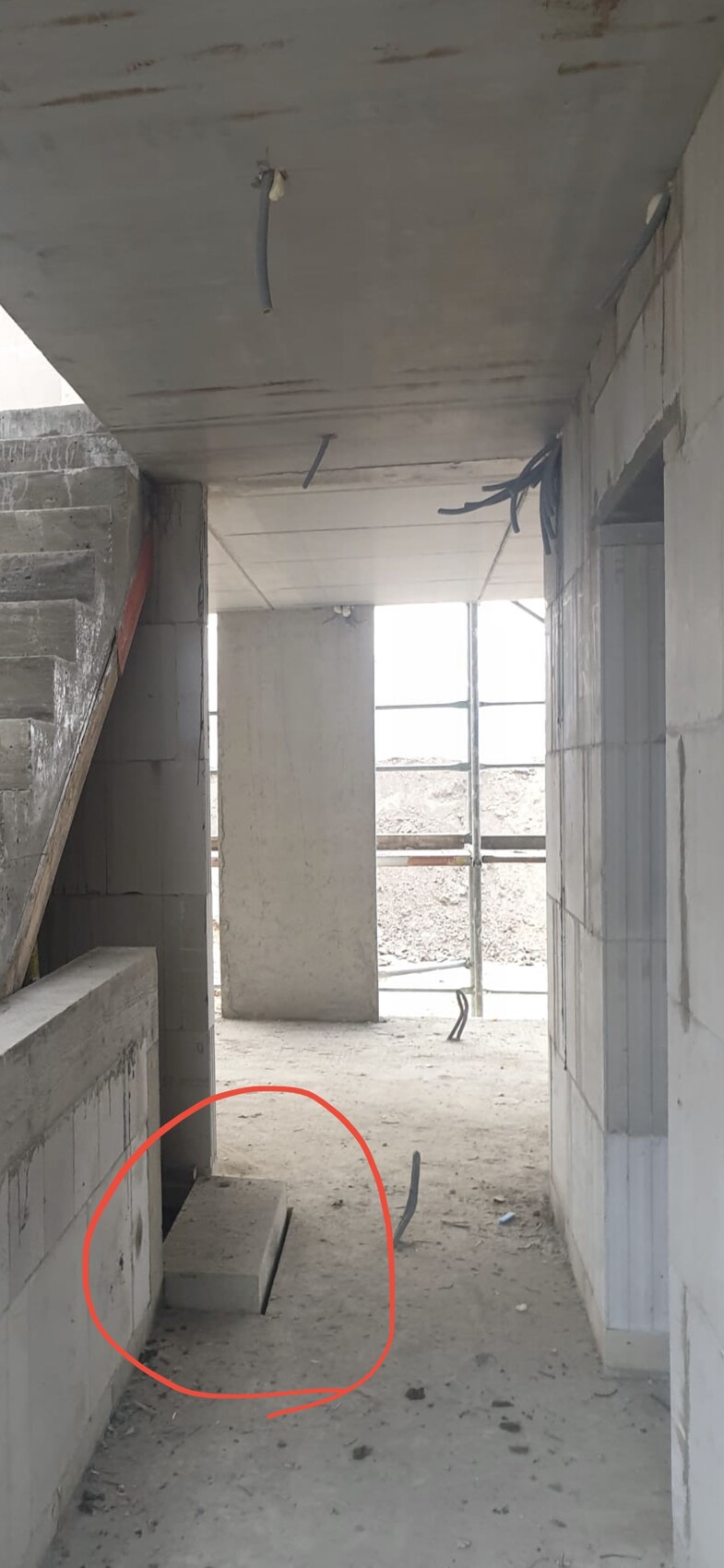 Interior view of shell construction with staircase and open concrete walls