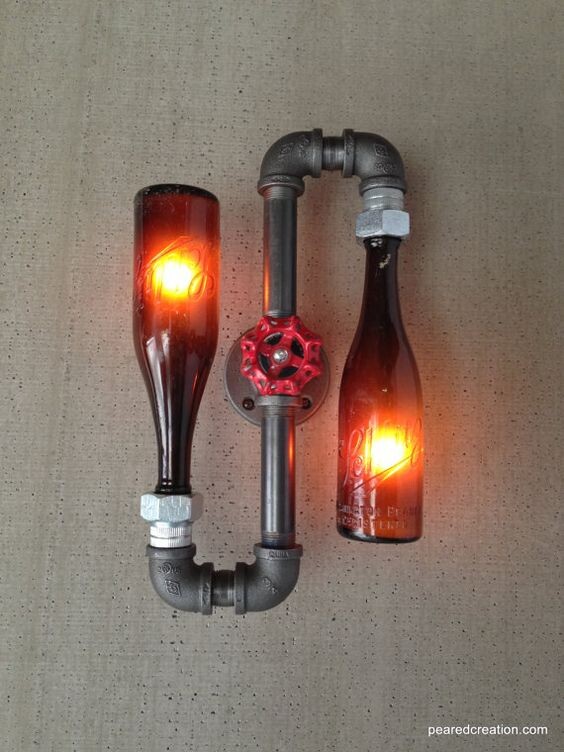 Upcycled lamp: two glass bottles as lamps, red glow, pipe valve connection.