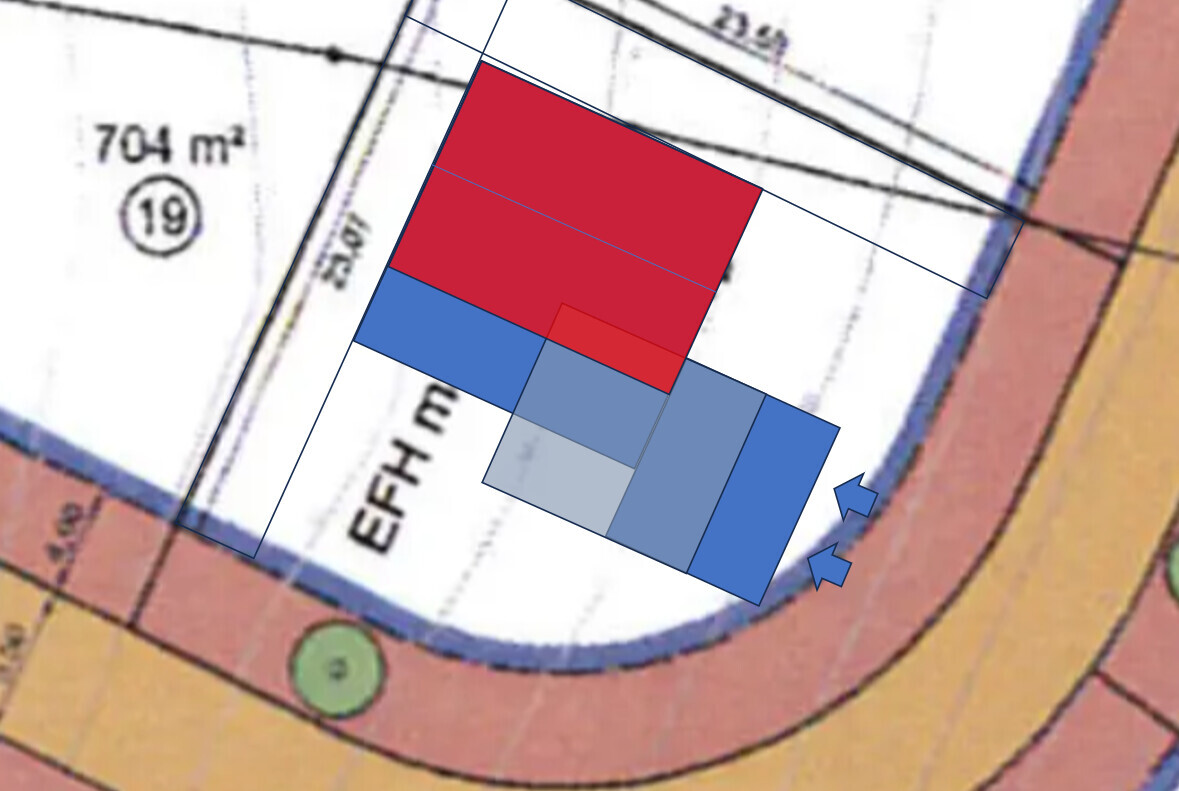 Map excerpt: Several red and blue rectangles over a plot next to a winding road.