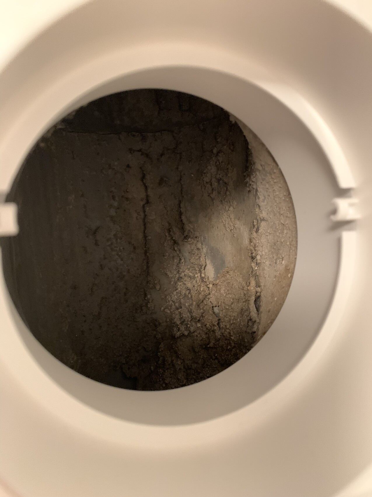 View inside a toilet: round opening with brown, crusty deposits on the inner base.