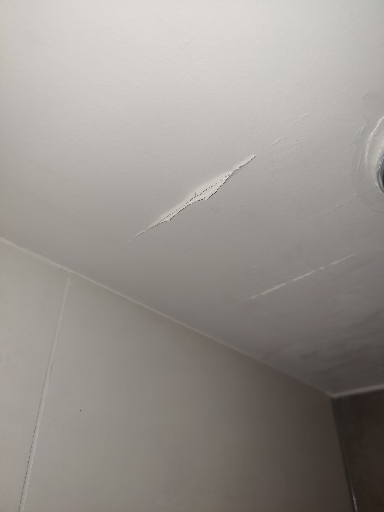 Ceiling with crack, corner of the wall bottom left, light fixture on the right.