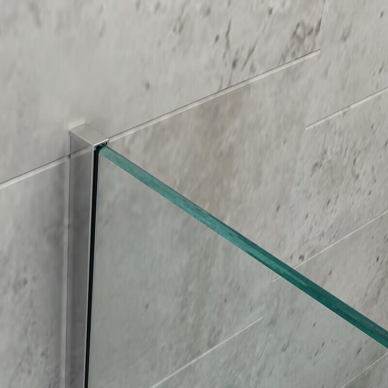 Green-tinted glass wall of a shower enclosure with metal frame in front of gray tiles.