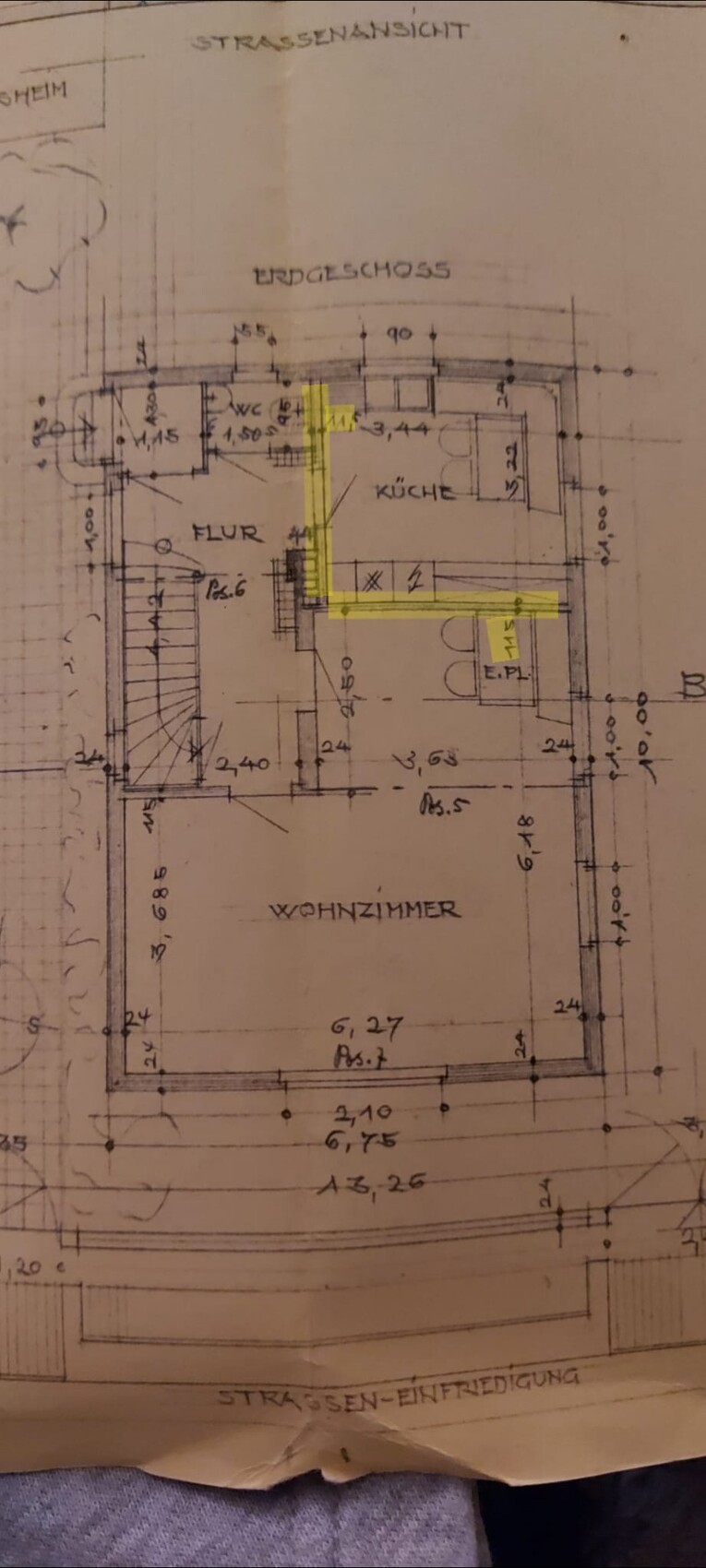 Architektonischer Grundriss des Erdgeschosses mit Wohnzimmer, Küche und Flur; gelb markierte Linien.
