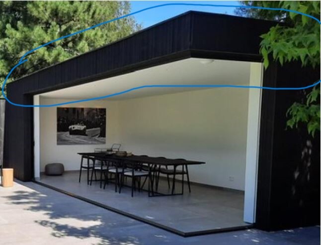 Open modern garage with white interior, long dining table and chairs.