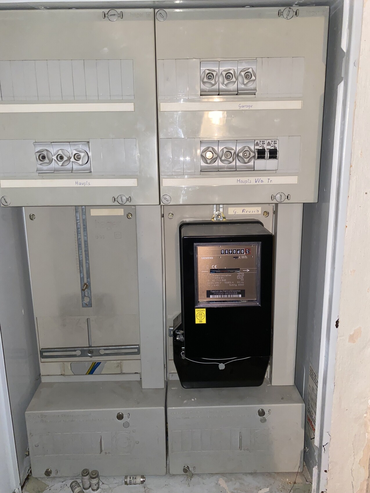Electrical distribution cabinet with meter, fuses, and display in gray enclosure.