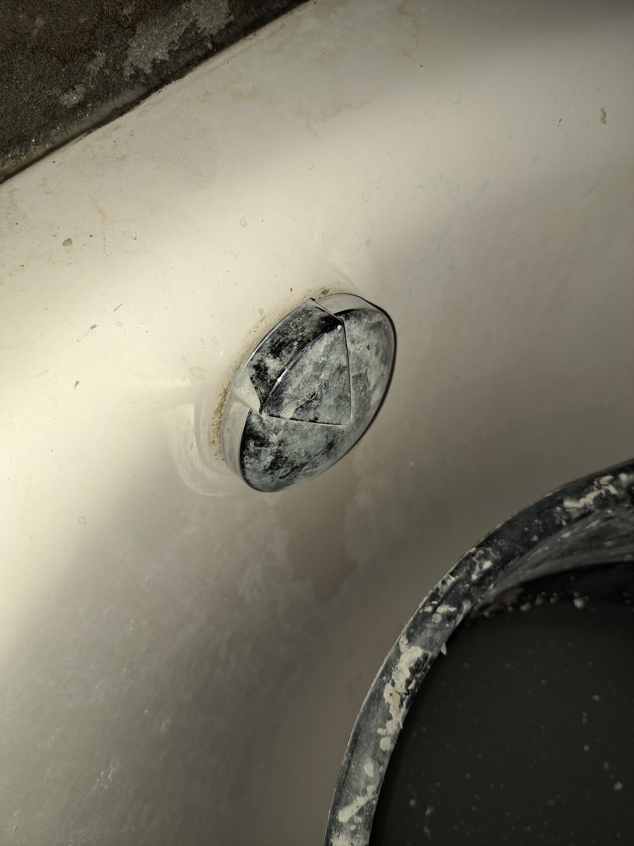 Round cover on dusty metal surface with a crack