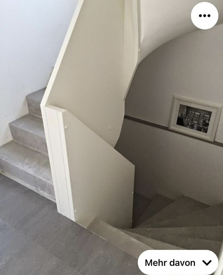 Spiraltreppe im Innenbereich eines Gebäudes mit grauen Stufen