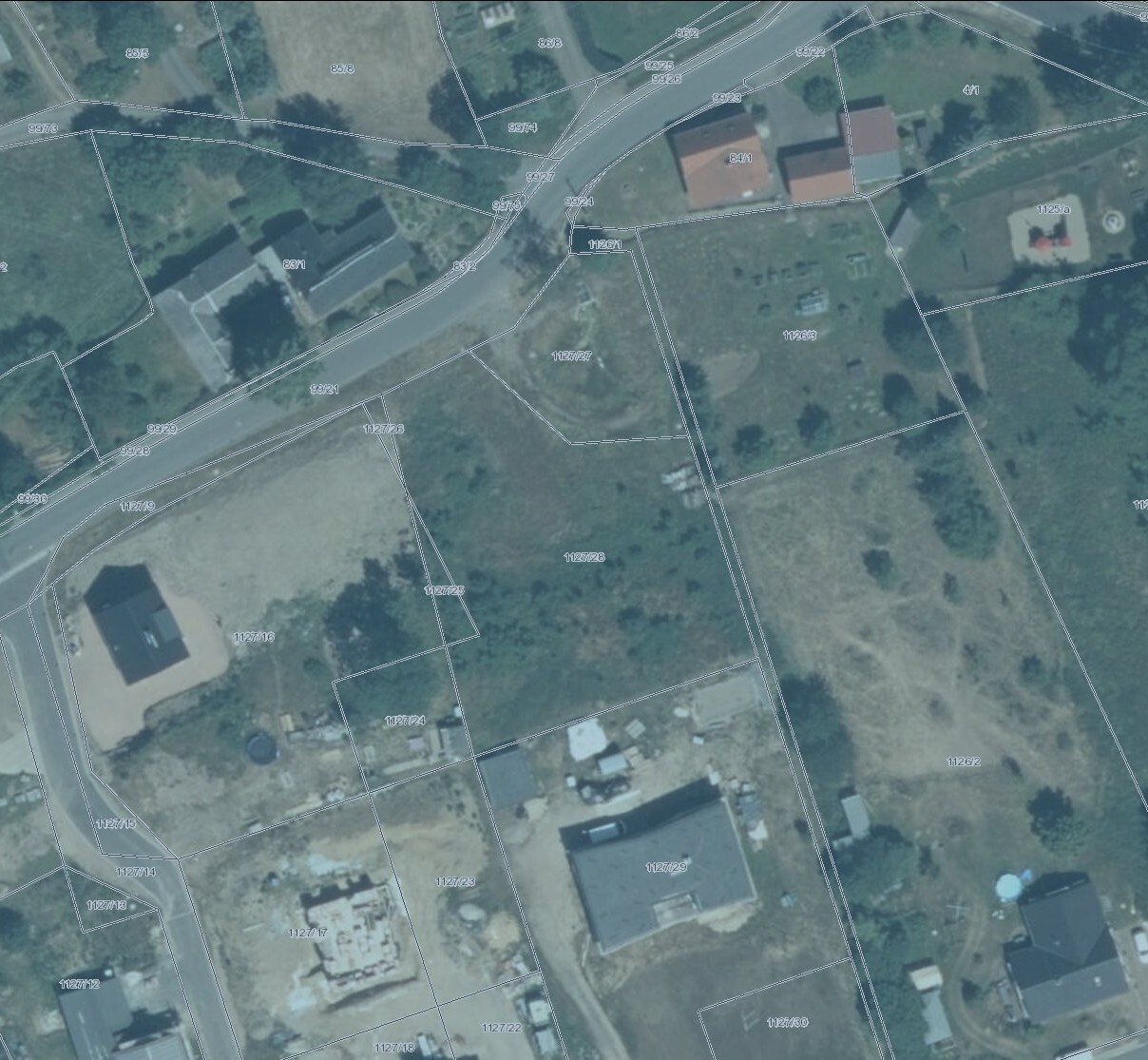 Aerial view of a street with land parcels and buildings.