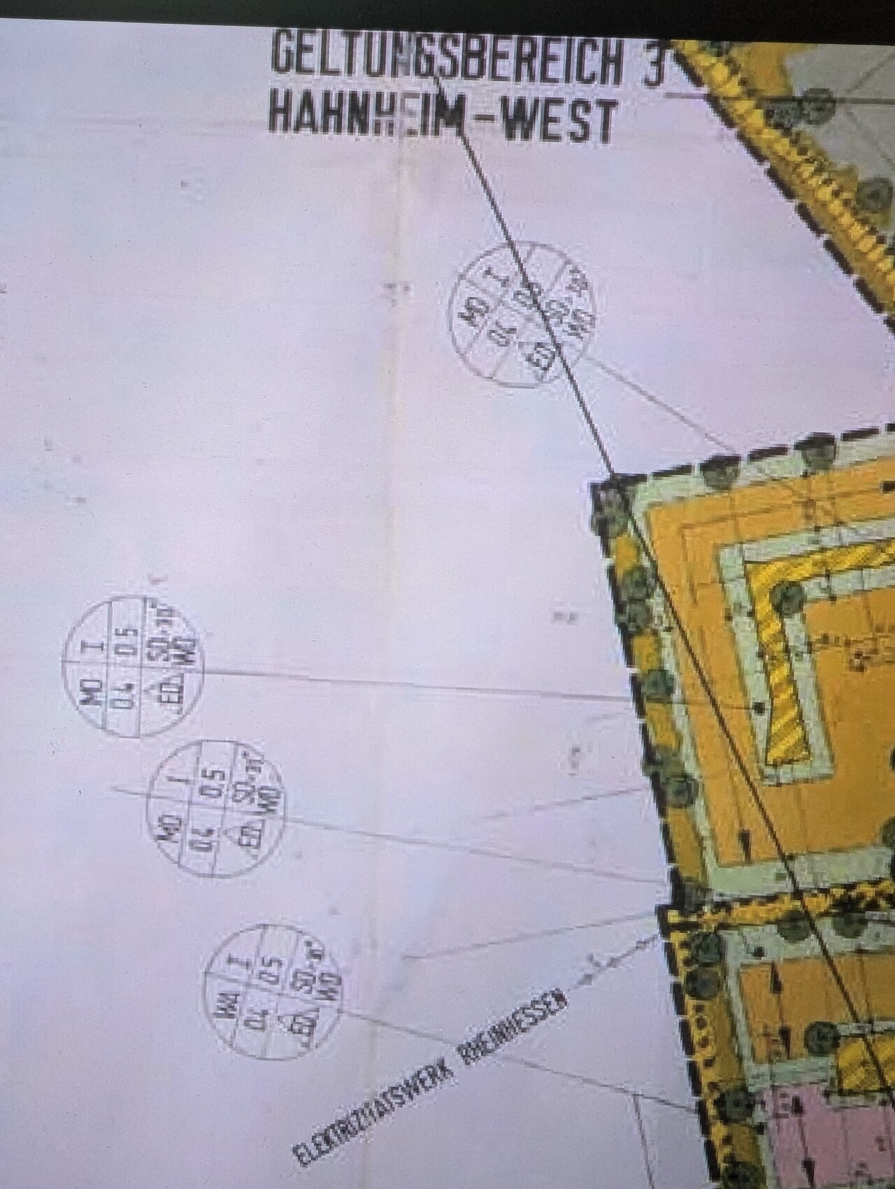 Architectural plan of a yellow building with circles and dimension markings on the edges.