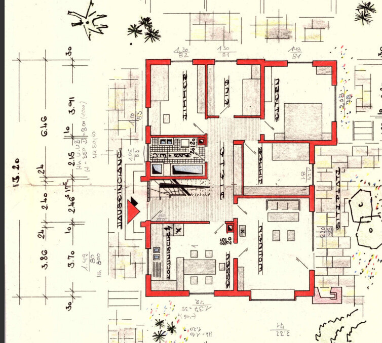 Floor plan of a house with red interior walls, furniture, and dimensions.
