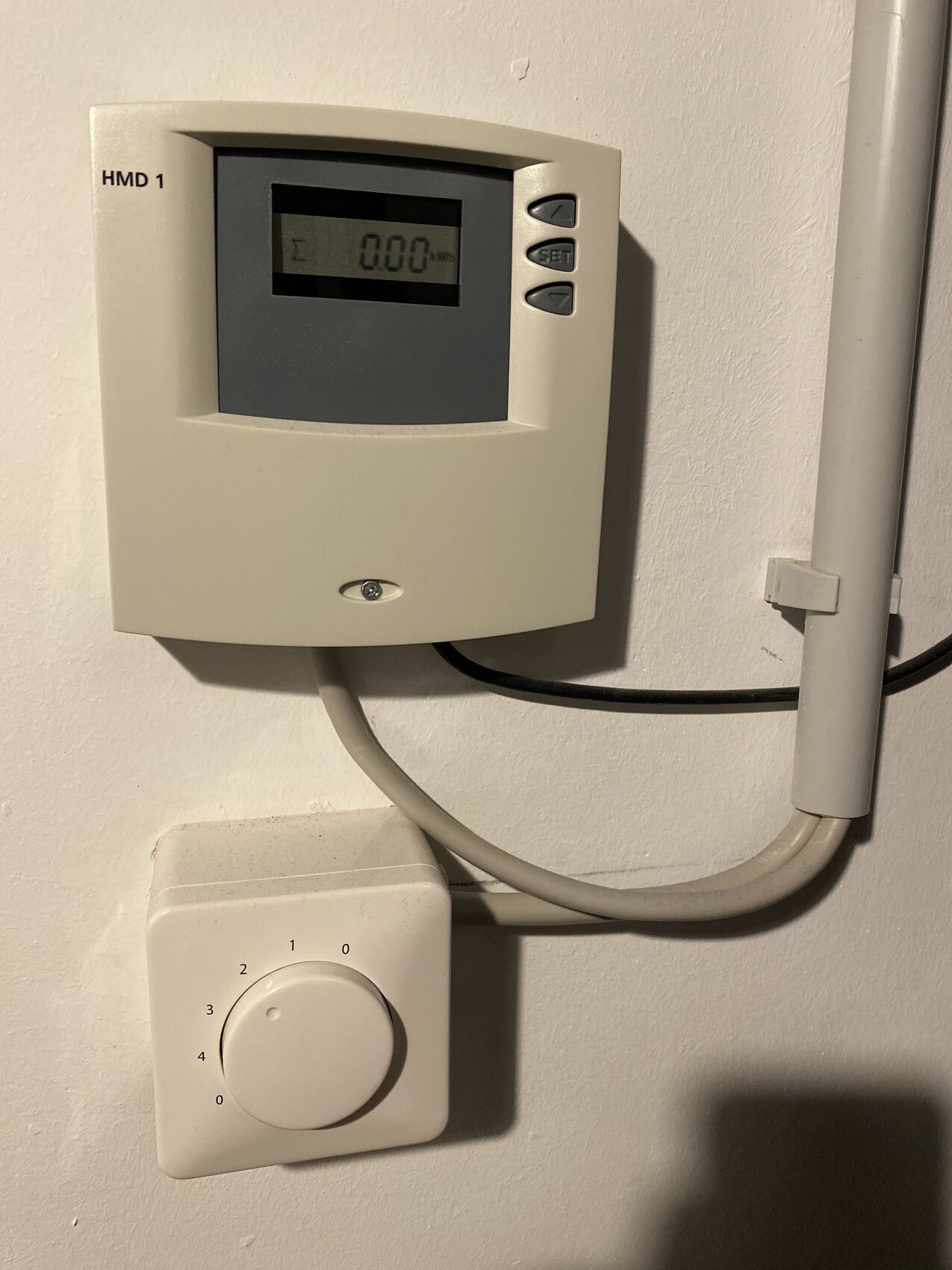 HMD 1 thermostat with digital display and next to it a round rotary knob, connected by a cable.