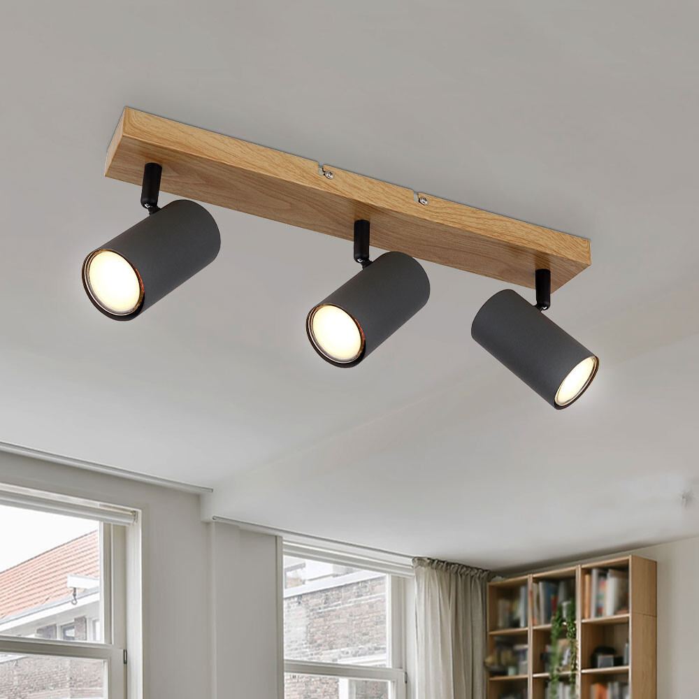 Three-light ceiling fixture with wooden beam and black spots in the living room.