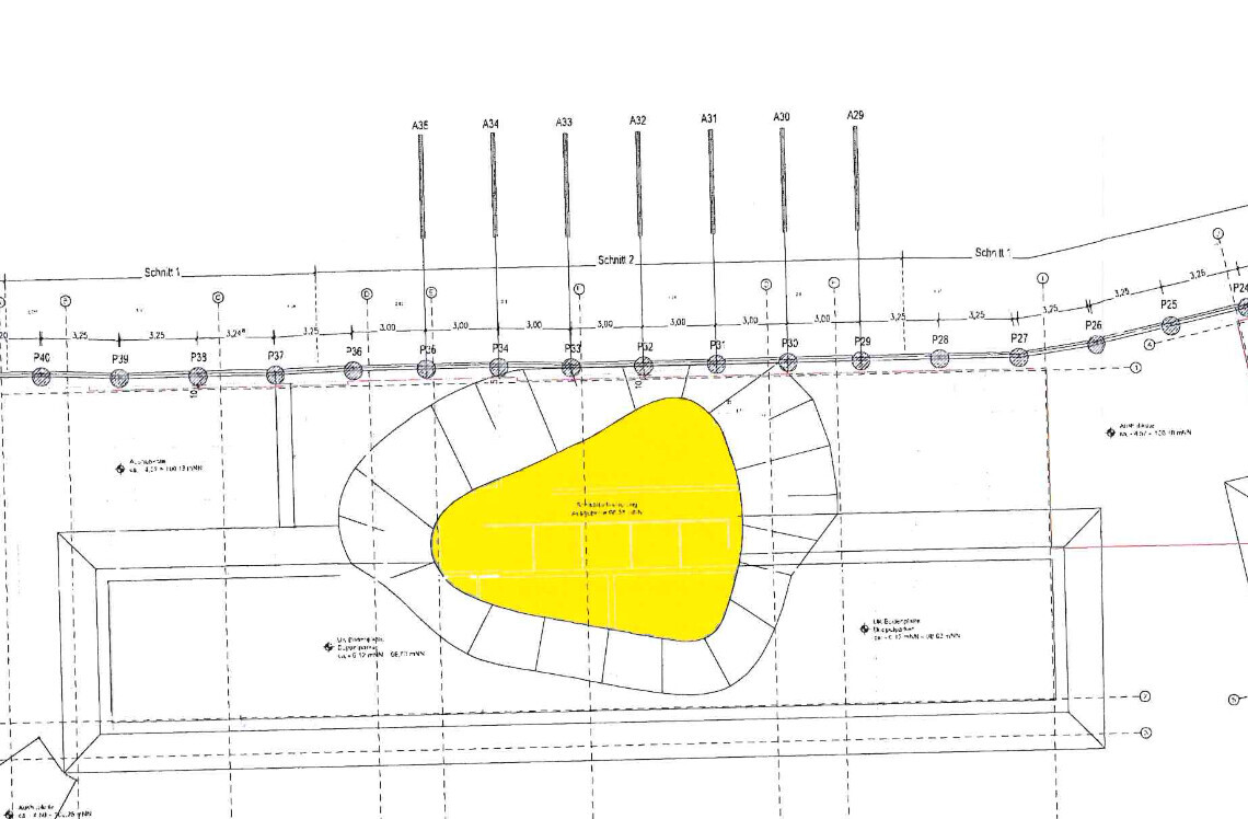 Technical drawing of a building plan with an interior area highlighted in yellow within an oval outline.