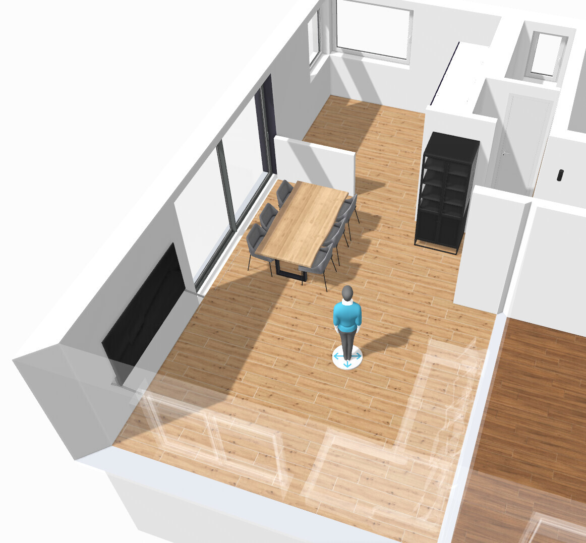 Open living and dining area with wooden floor, dining table, chairs, black shelf, and a person.