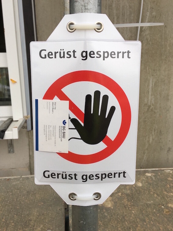 Sign 'Scaffolding closed' with red prohibition symbol at a construction site