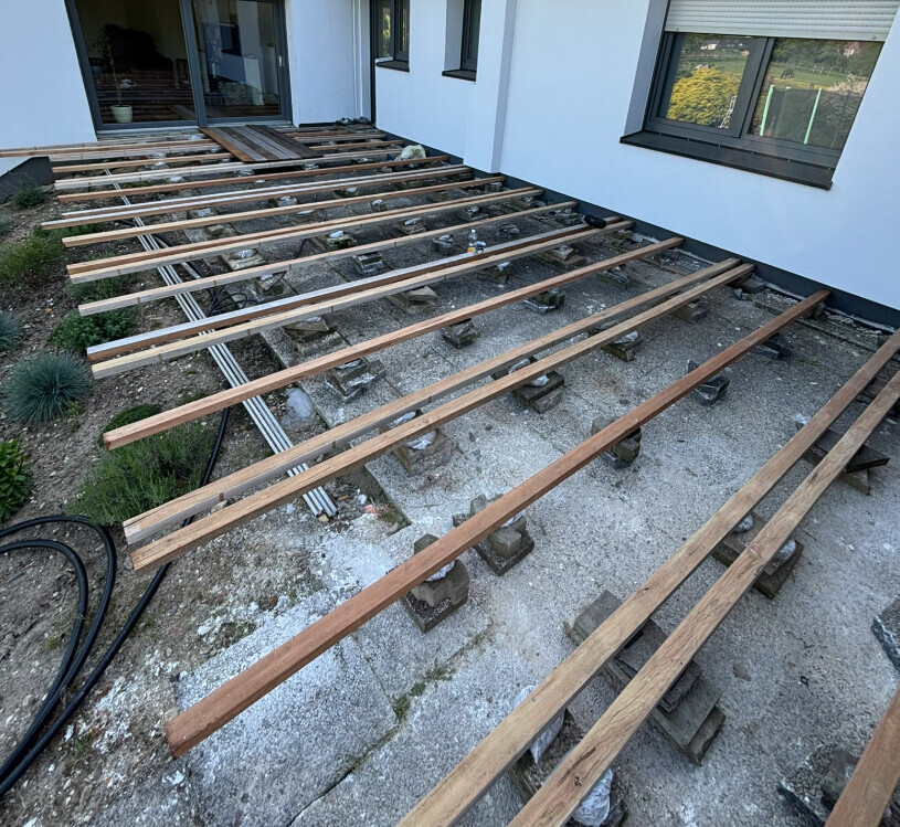 Outdoor area: wooden beam substructure on concrete blocks, ready for the terrace.