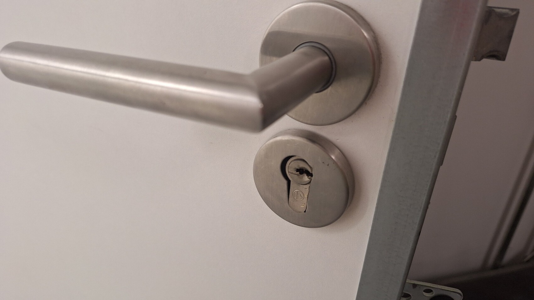 Stainless steel door handle with round rosette lock and keyhole