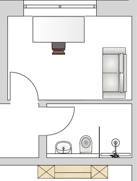 Floor plan of a room: sofa on the right, table in the middle, door on the left, bathroom with sink and toilet.