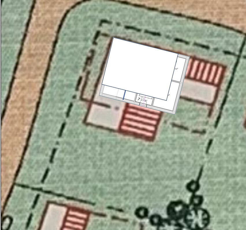 Site plan of a plot with a white building footprint overlaid, red areas visible.