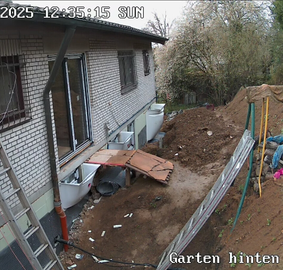 Outdoor area of a house under shell construction with earthworks, foundations and garden preparation.