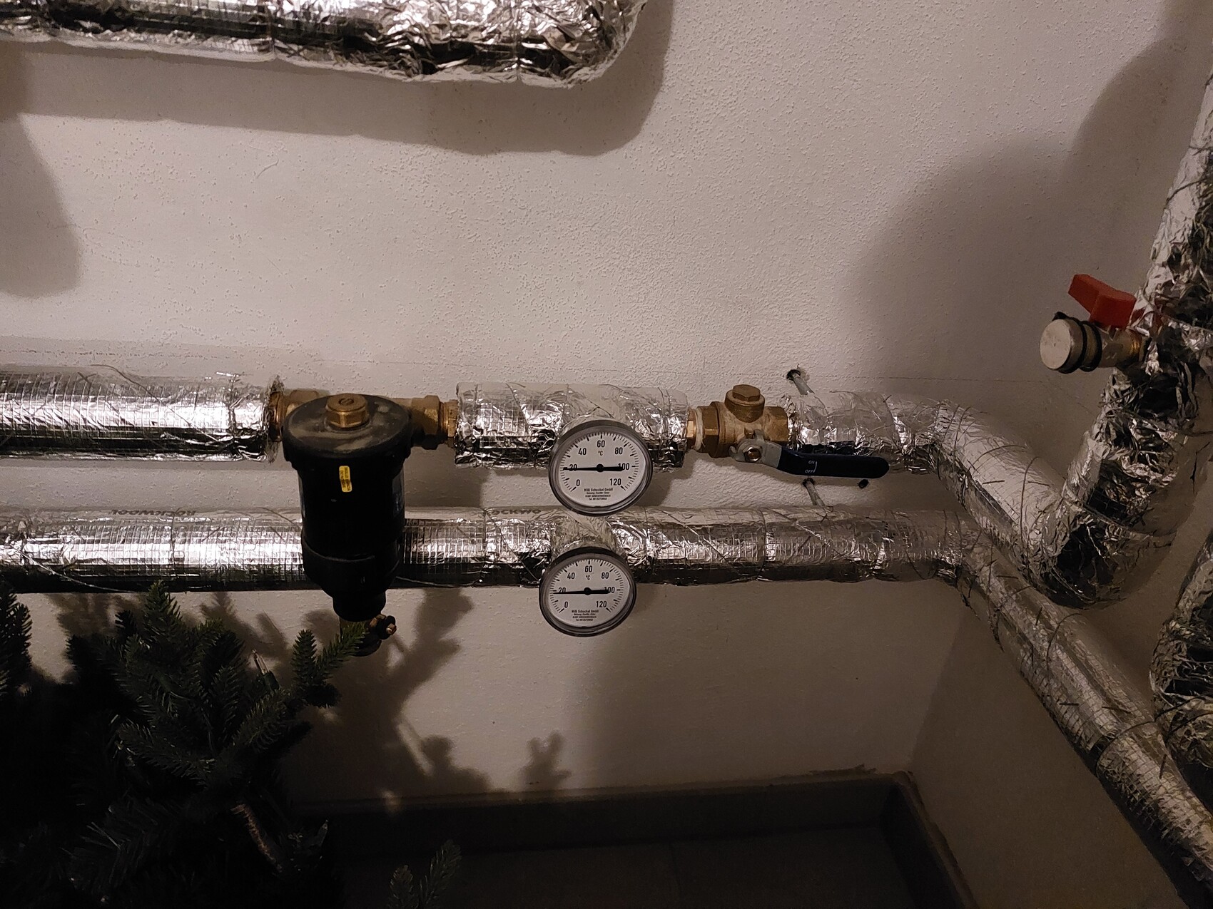 Insulated pipes with two pressure gauges and a valve in the heating basement