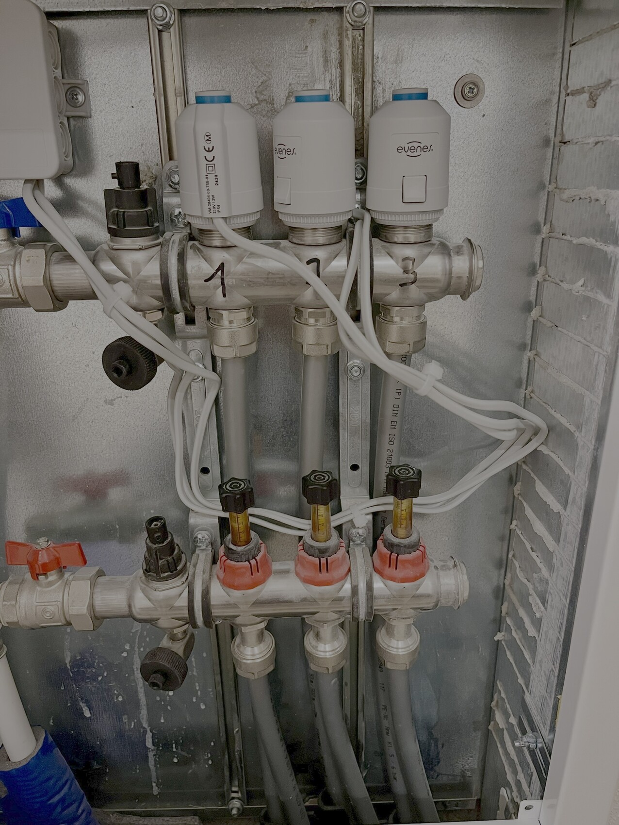 Distribution system with valves, pipes and cables in heating installation.