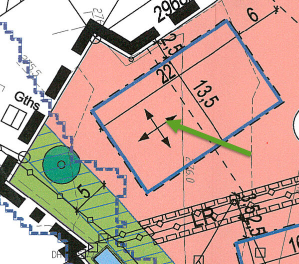 Site plan with floor plan, blue lines, pink building area, green arrow