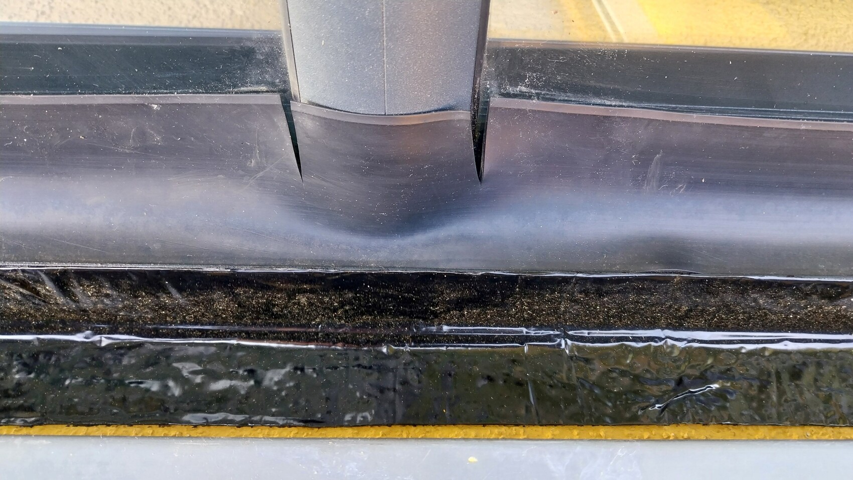 Close-up of a black door or window sealing profile on the frame with a gap