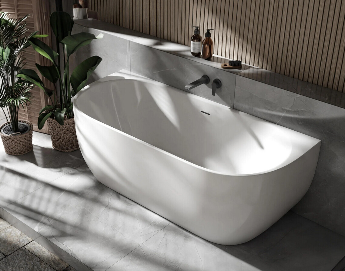 Modern freestanding white bathtub with gray tiles, wood panel wall, and plant corners.
