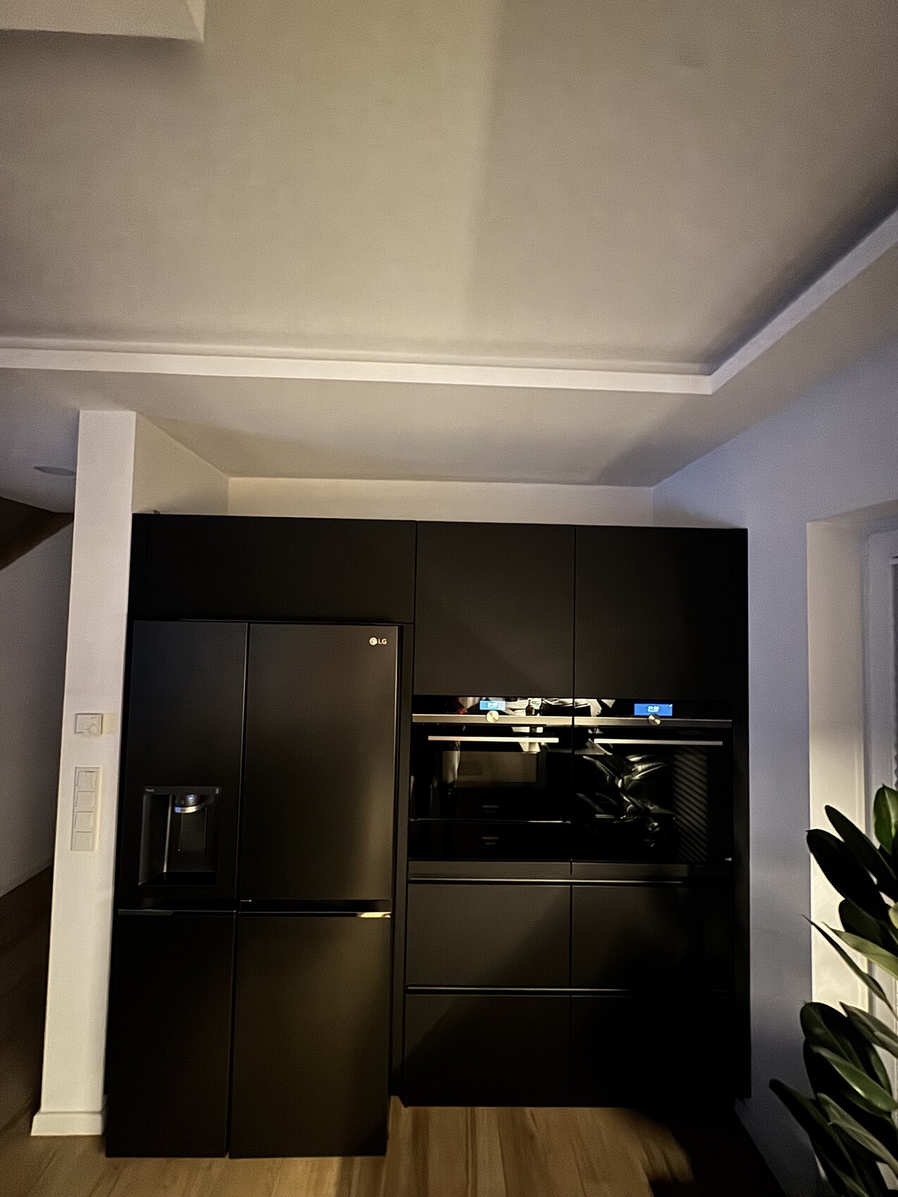 Moderne-kueche-mit-schwarzen-einbaugeraeten-kuehlschrank-und-backofen