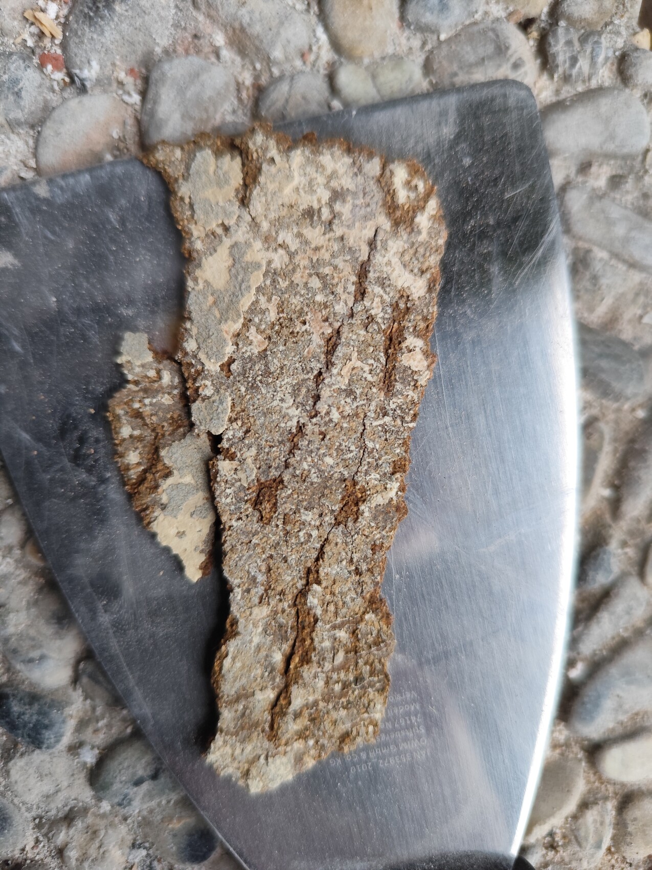 Metal shovel with dried mortar on stone floor