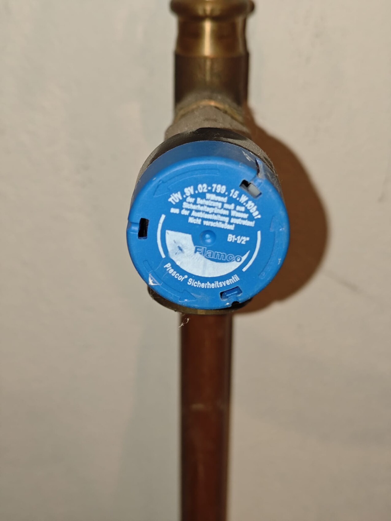 Blue safety valve cap on copper pipe of a water line, installation connection visible