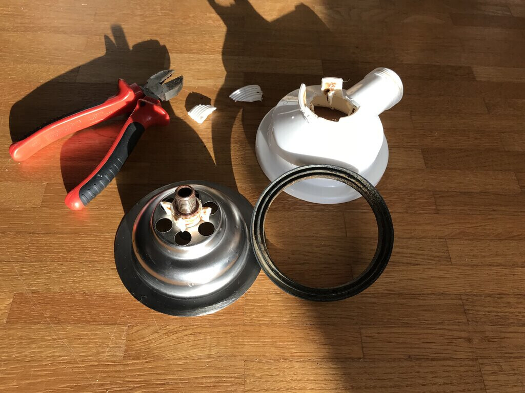 Lampe Ersatzteile auf Holzboden: Zange, Fassung, Dichtungsring, Abdeckkappe
